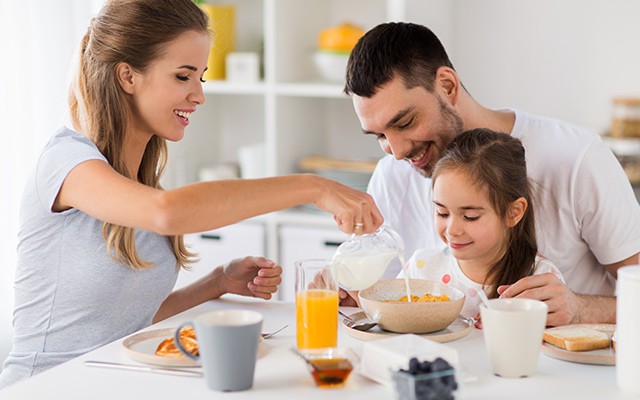 Eine Familie isst gemeinsam Frühstück am Tisch.