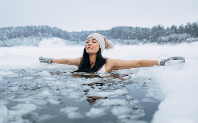 Eine Frau badet im Winter in eisigem Wasser.