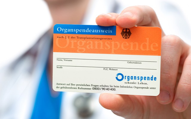 Eine Person hält einen deutschen Organspendeausweis in der Hand.