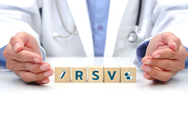 Ein Arzt hält Holzklötze mit den Buchstaben "RSV" zwischen seinen Händen.